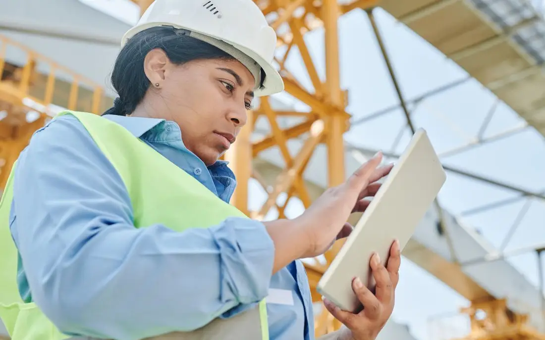 Site engineer checking a tablet on a construction site