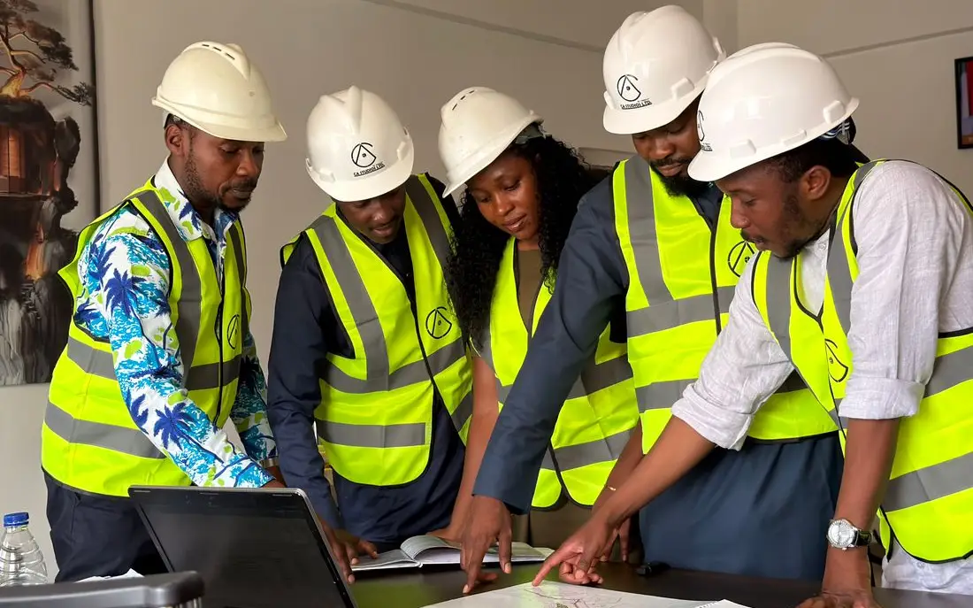 A site team in hard hats and hi-vis reviewing drawings together